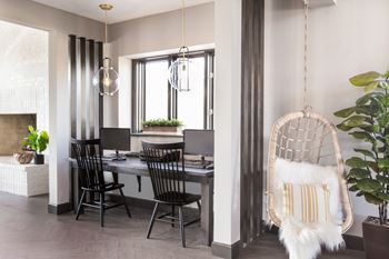 two work stations with chairs and computer monitors with decorations at Evansville Apartments